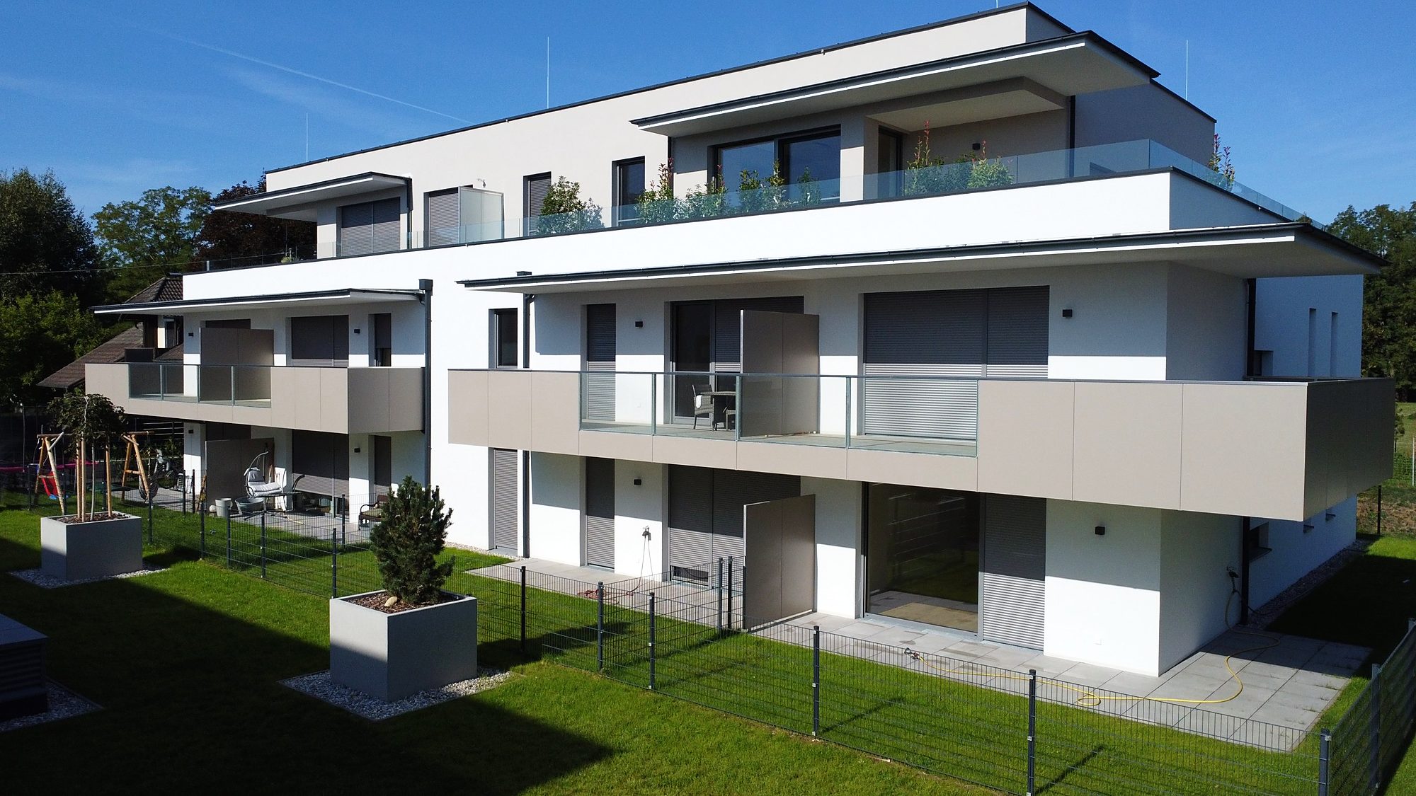 Gartenseite der Anlage mit Terrasse und Eigengarten von TOP 4 im Erdgeschoß